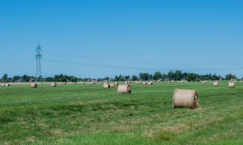 Hay bales on field against sky