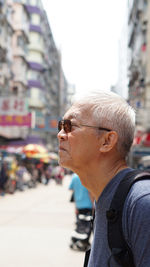 Portrait of man with arms raised on street in city