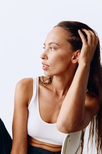 Young woman looking away against white background