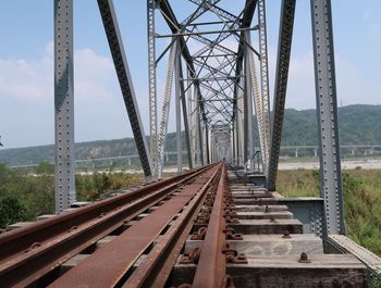 Diminishing perspective of railway bridge against sky