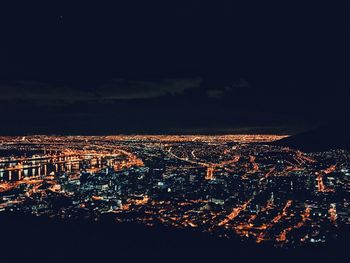 Illuminated cityscape against sky at night