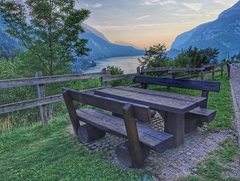 Empty bench on field by mountains
