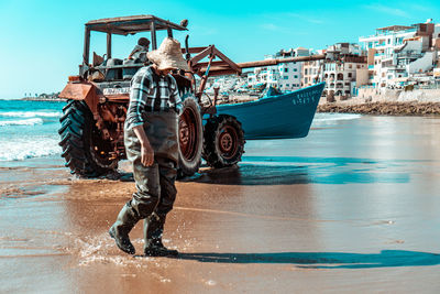 Full length of man standing on sea shore against sky