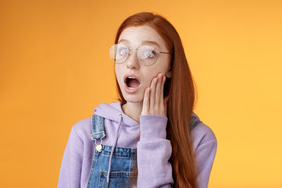 Portrait of beautiful young woman over yellow background