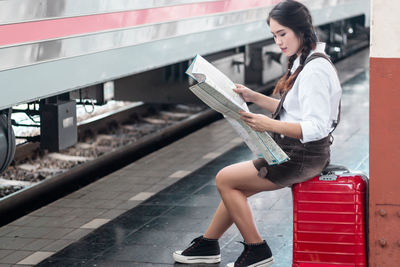 Full length of young woman using mobile phone