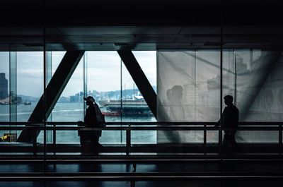 Silhouette people standing on bridge