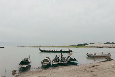 Boats moored on sea against clear sky