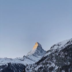 Scenic view of snowcapped mountains against clear sky