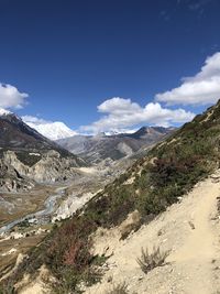 Scenic view of mountains against blue sky