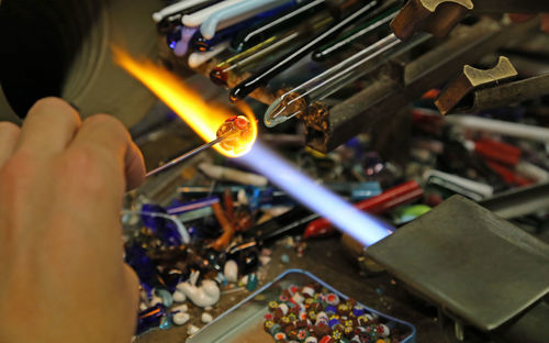 Cropped worker heating gemstone on flaming torch