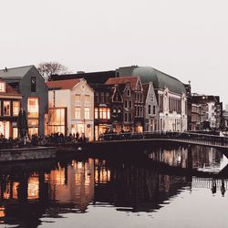 Reflection of buildings in lake against sky in city