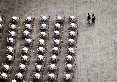 High angle view of people walking by sidewalk cafe