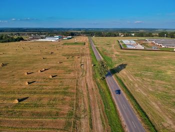 High angle view of street amidst field against sky