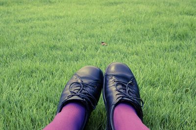 Low section of person standing on grassy field