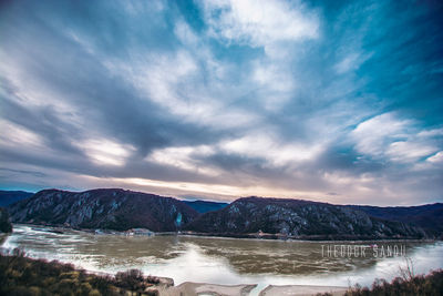 Scenic view of lake and snowcapped mountains against sky