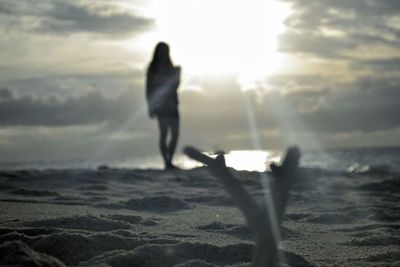 Rear view of woman standing on beach