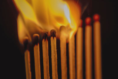 Close-up of burning matchsticks against black background