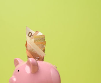 High angle view of coins on head against yellow background