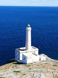 Lighthouse by sea against sky