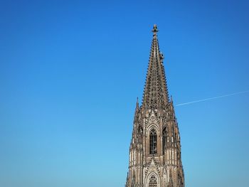 Low angle view of bell tower against blue sky