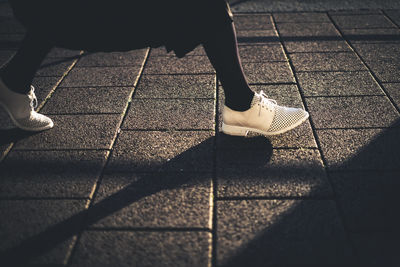 Low section of woman walking on footpath