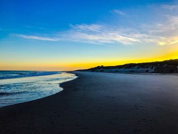 Scenic view of beach against sky during sunset