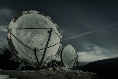 Abandoned boat on field against sky