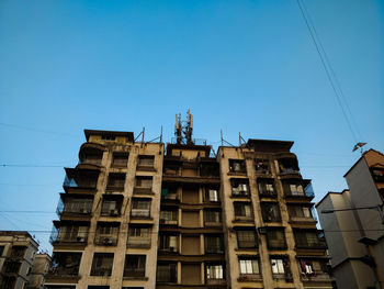 Low angle view of buildings against clear blue sky