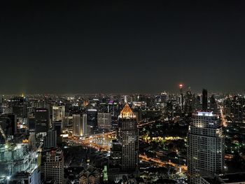 Illuminated cityscape against sky at night