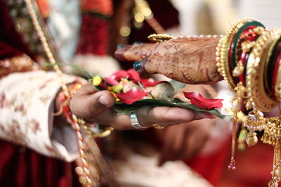 Close-up of hand holding cross against blurred background