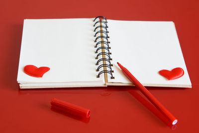 High angle view of pencil on table against red background