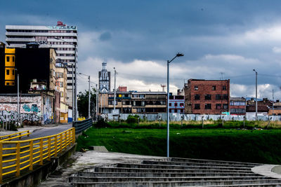 Street by buildings against sky in city