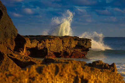 Panoramic view of rock formation on sea against sky