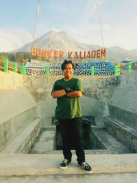 Portrait of young man standing against mountain
