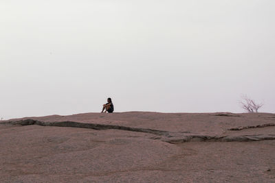 Full length of man on arid landscape against clear sky
