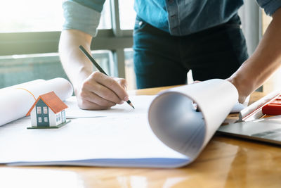 Midsection of person working with book on table