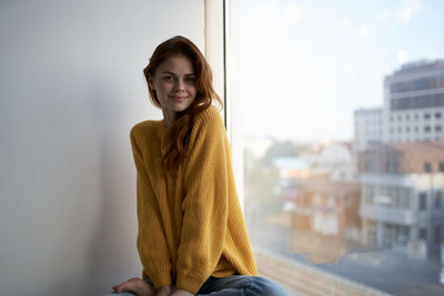 Portrait of smiling young woman sitting outdoors