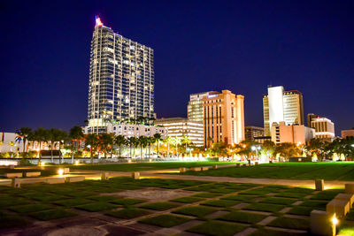 Illuminated buildings against sky at night