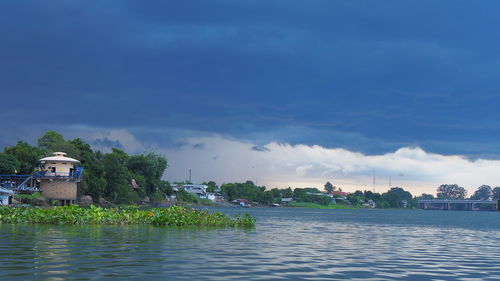 Scenic view of lake by buildings against sky