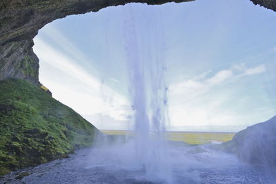 Scenic view of waterfall against sky