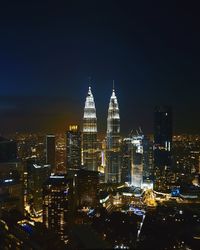 Illuminated petronas towers in city at night