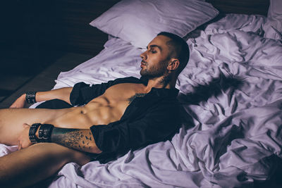 High angle view of man lying on bed