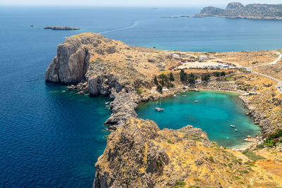 Scenic view from the acropolis of lindos at the coastline of the mediterranean sea and st. pauls bay