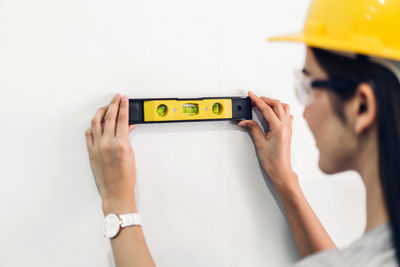 Midsection of woman holding text against wall