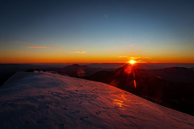 Scenic view of snowcapped mountains against sky during sunset