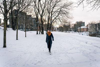 Wide viewing angle on a woman walking through a snowy winter city