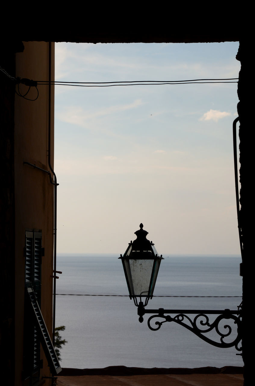 sky, light, architecture, iron, lighting equipment, nature, sea, no people, water, black, window, built structure, lighting, sunset, white, street light, cloud, darkness, railing, silhouette, outdoors, building exterior, interior design, lamp, electric lamp, beauty in nature, day, horizon over water