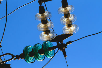 Low angle view of light bulb against blue sky