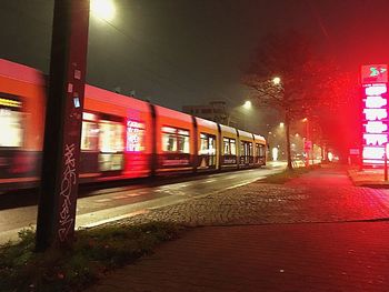 Train on illuminated street at night
