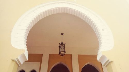 Low angle view of electric lamp hanging on wall